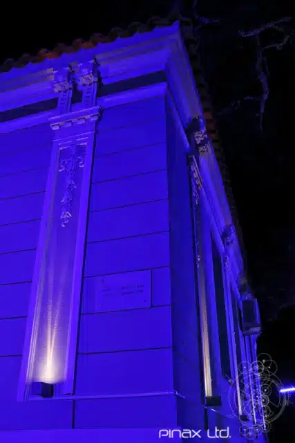Ιστορική αρχιτεκτονική όψη με μωβ φωτισμό που αναδεικνύει διακοσμητικές λεπτομέρειες