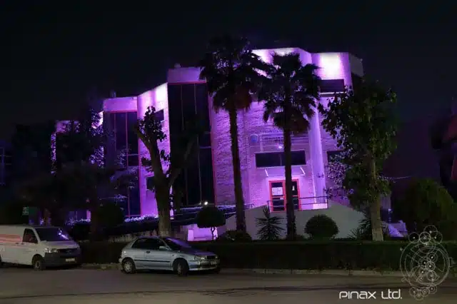 Σύγχρονο κτίριο με έντονο μωβ και φούξια αρχιτεκτονικό φωτισμό