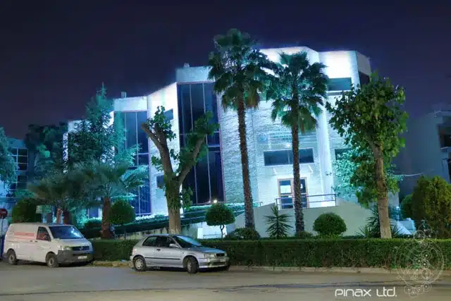 Σύγχρονο δημόσιο κτίριο με κυανό αρχιτεκτονικό φωτισμό κατά τη νύχτα